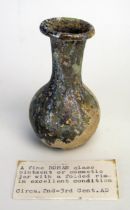 A Roman glass cosmetic bottle, of ovoid form with flared long neck and folded rim, 8cm high 2nd -