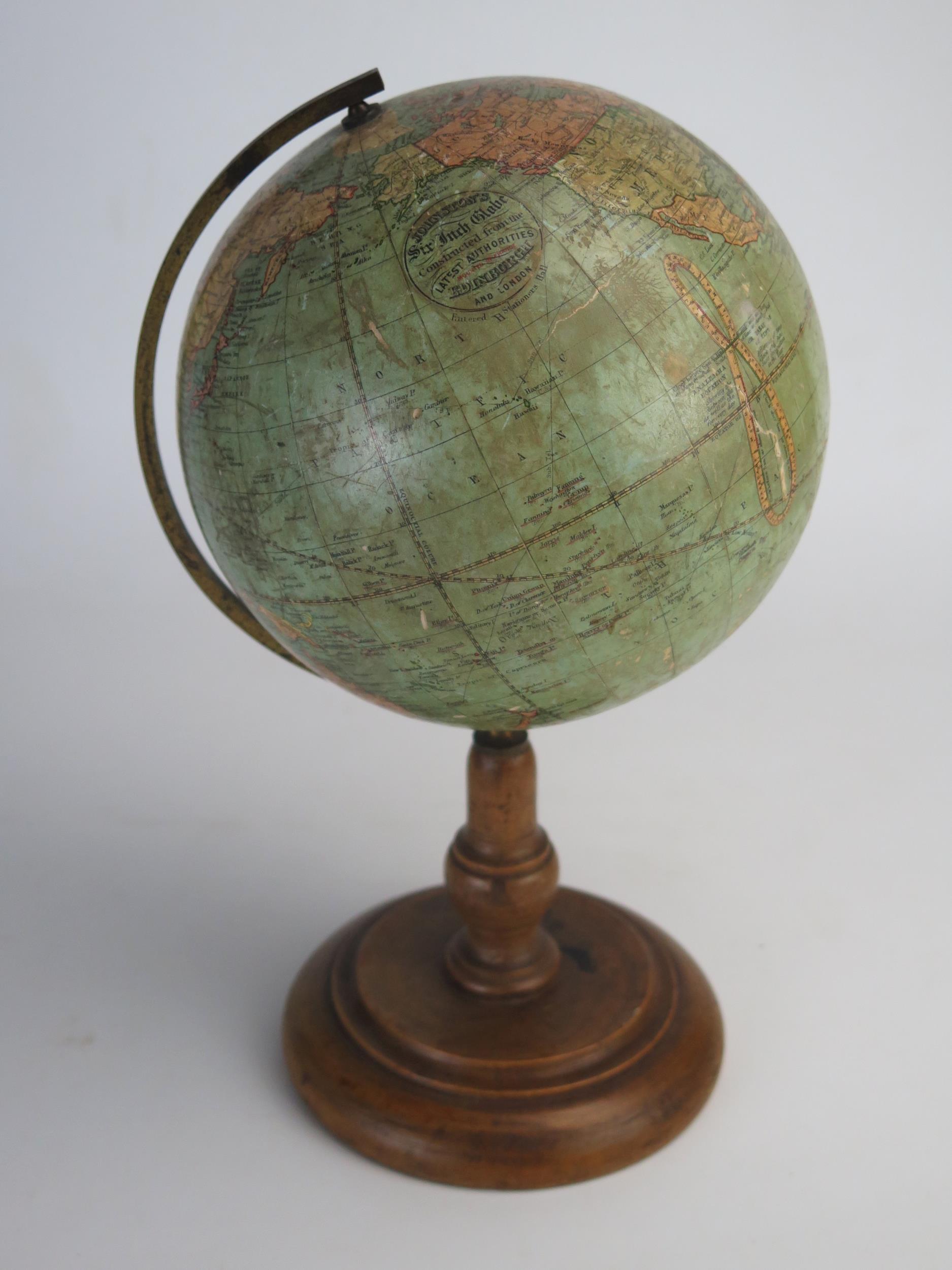 A Johnson's six inch terrestrial globe, on brass frame and turned wood circular base, overall height