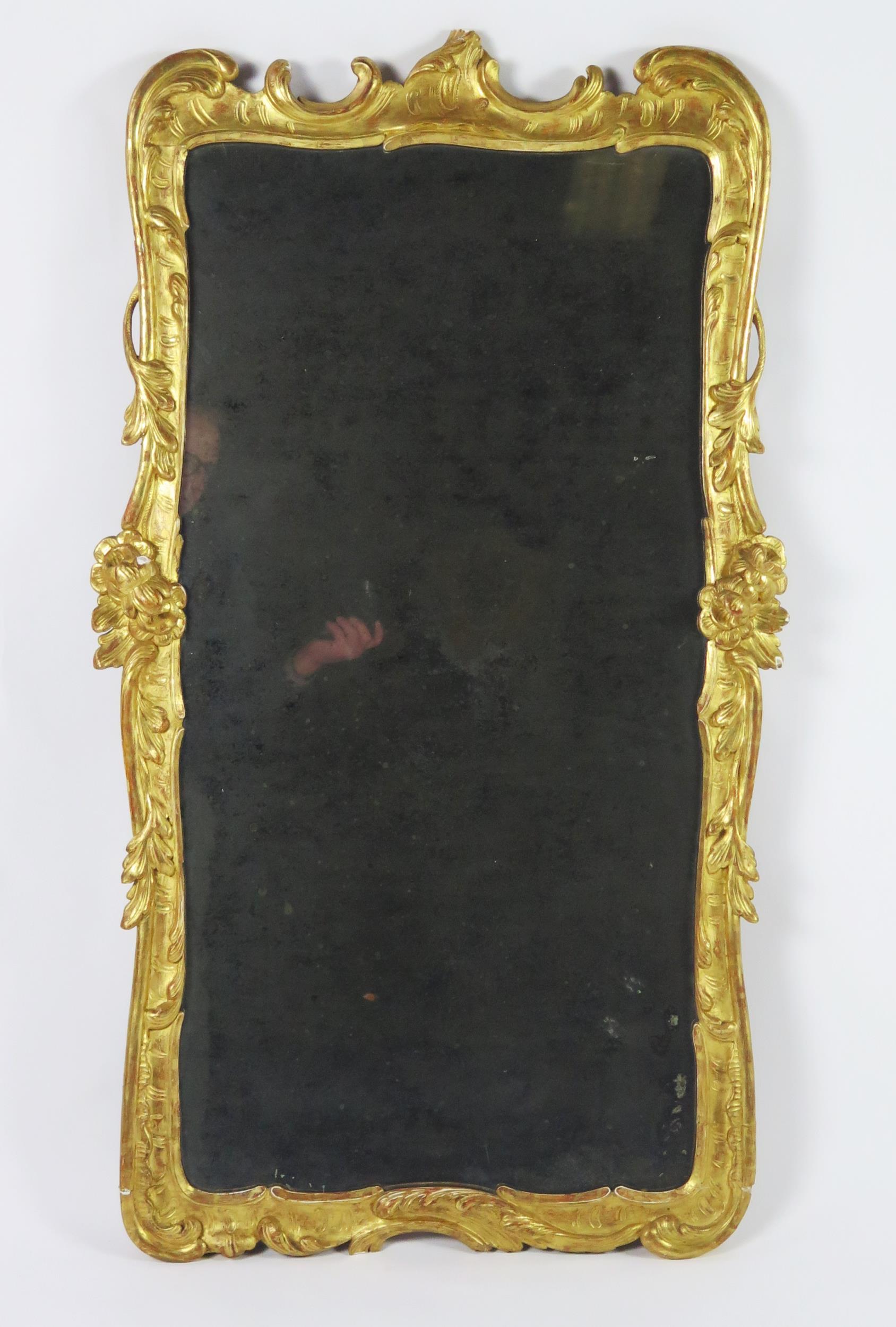A late 18th century gilt and gesso pier glass, the rectangular mirror plate enclosed by floral and