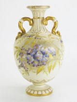 A Royal Worcester blush ivory vase, with painted wisteria pattern decoration the handles in the form