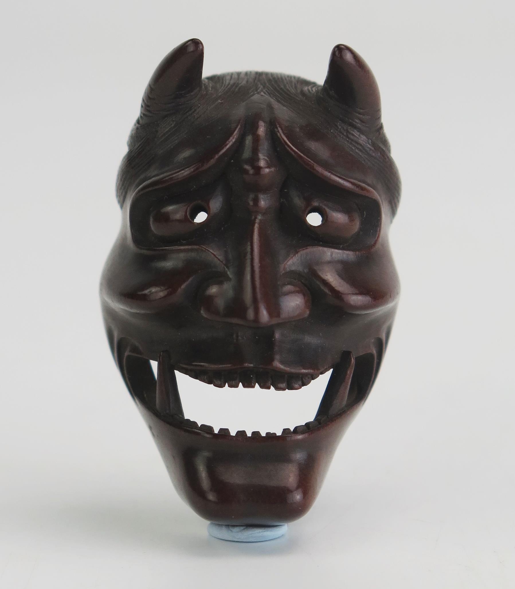 A Japanese carved boxwood netsuke of a noh theatre Hannya mask, signed Doraku, 4.5cm high. Meiji - Image 3 of 3