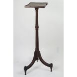 An Edwardian mahogany torchiere stand with square top raised on a fluted and knopped column and