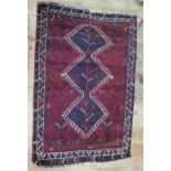 A Hamadan rug, the wine red field with triple , hooked pole medallion, enclosed within a triple