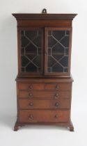An apprentices mahogany book case on chest, with moulded cornice, a pair of astragal glazed panelled