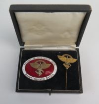 A Third Reich period N.S.F.K. events badge, with red and white enamel decoration, stamped Rob. Neff.