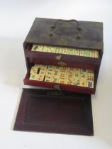 A bone and bamboo Mah Jong set, contained in a fitted cabinet.