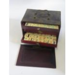 A bone and bamboo Mah Jong set, contained in a fitted cabinet.