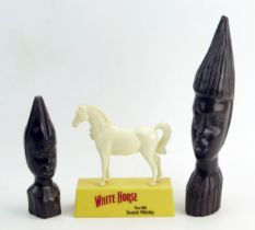 Two African carved wood busts, 26cm and 16cmmhigh, together with a plastic advertising figure for