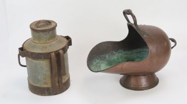 A Victorian copper coal scuttle of helmet outline, with loop handle on a circular foot, together