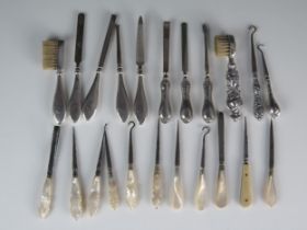 A collection of silver handled and mother-of-pearl handled manicure items, nail files, button hooks,