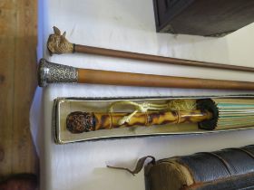 A Malacca and silver mounted walking cane, a swagger stick and a Japanese parasol with painted