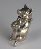 A continental silver novelty vesta case, in the form of a pig, holding a bag of money, stamped