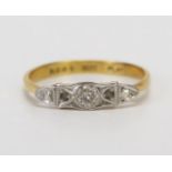 An 18ct Gold and Diamond Three Stone Ring platinum set with an old cut flanked by rose cuts, size