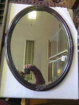 An oval framed wall mirror, 53cm x 68cm