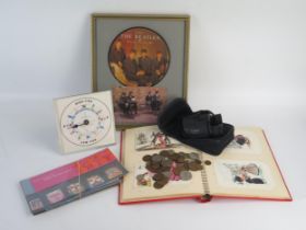 A collection of modern postcards contained in an album, assorted stamps, coins and binoculars