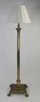 A brass telescopic Corinthian column standard lamp, with reeded column on a square base with talon