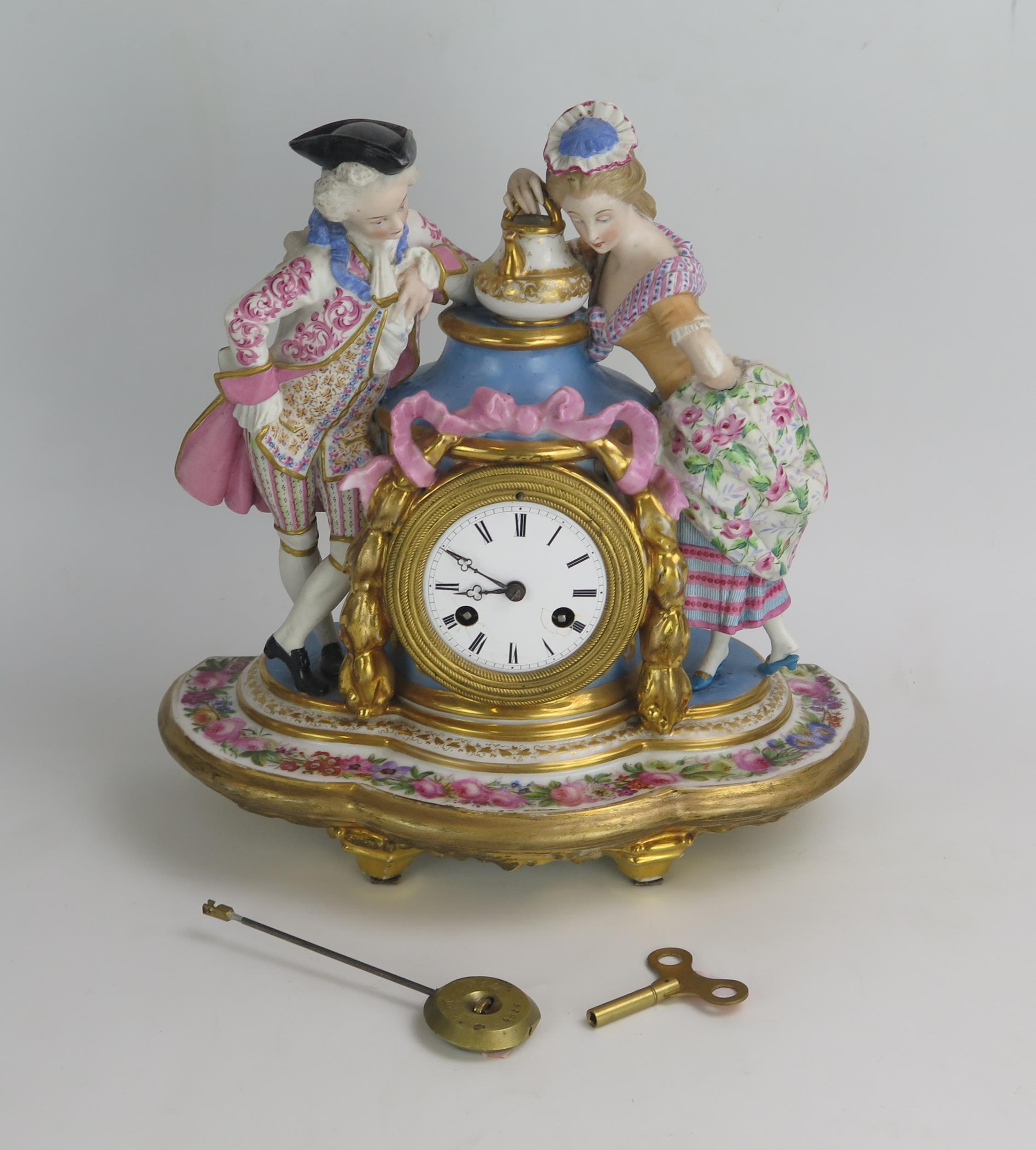 A 19th century French porcelain figural mantel clock, the urn-shaped case flanked by a gallant and