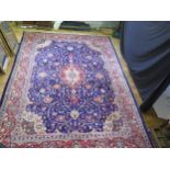 A Persian design carpet, the indigo field, with wine red floral pole medallion, enclosed with