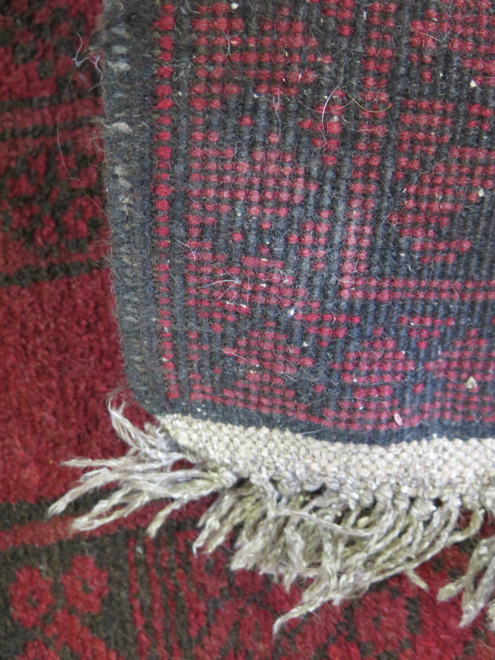 An Afghan rug, the wine red field with single row of three octagonal medallions, within a multiple - Image 2 of 2