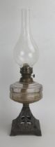 A Victorian Oil Lamp with a slice cut glass reservoir and on a pierced cast iron base decorated with