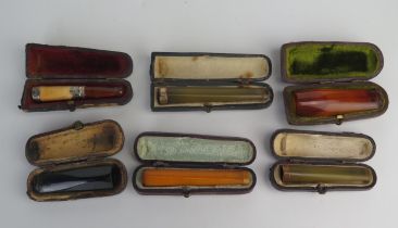 A collection of six assorted amber and other cheroot holders, all cased.