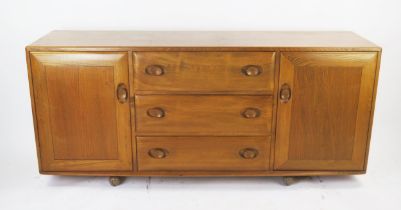 An Ercol Mid Elm Sideboard with three central drawers and cutlery tray flanked by a cupboard to each