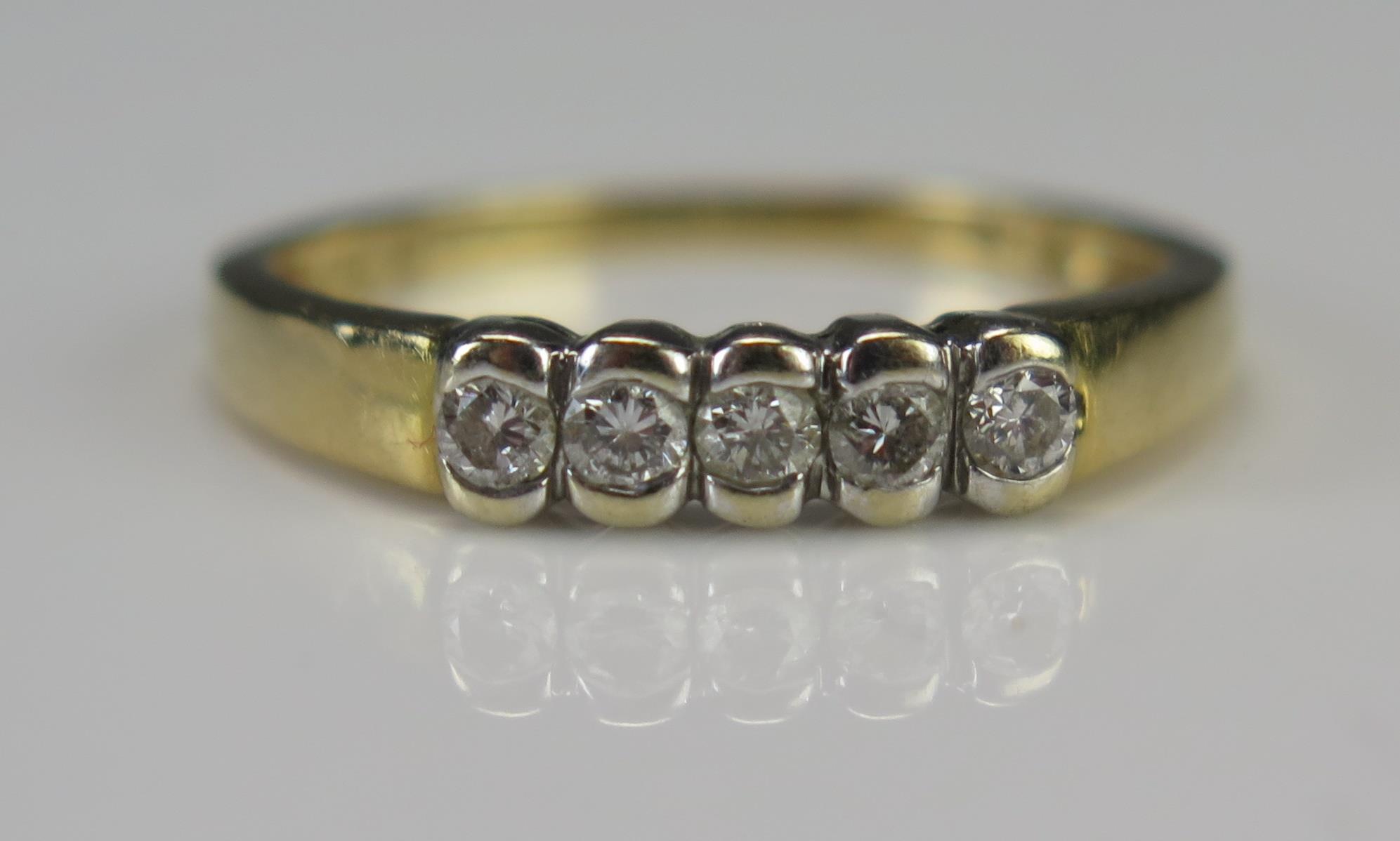 A Modern 18ct Gold and Diamond Five Stone Ring, size M.5, stamped 750 and with .2cts of diamonds,