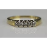 A Modern 18ct Gold and Diamond Five Stone Ring, size M.5, stamped 750 and with .2cts of diamonds,