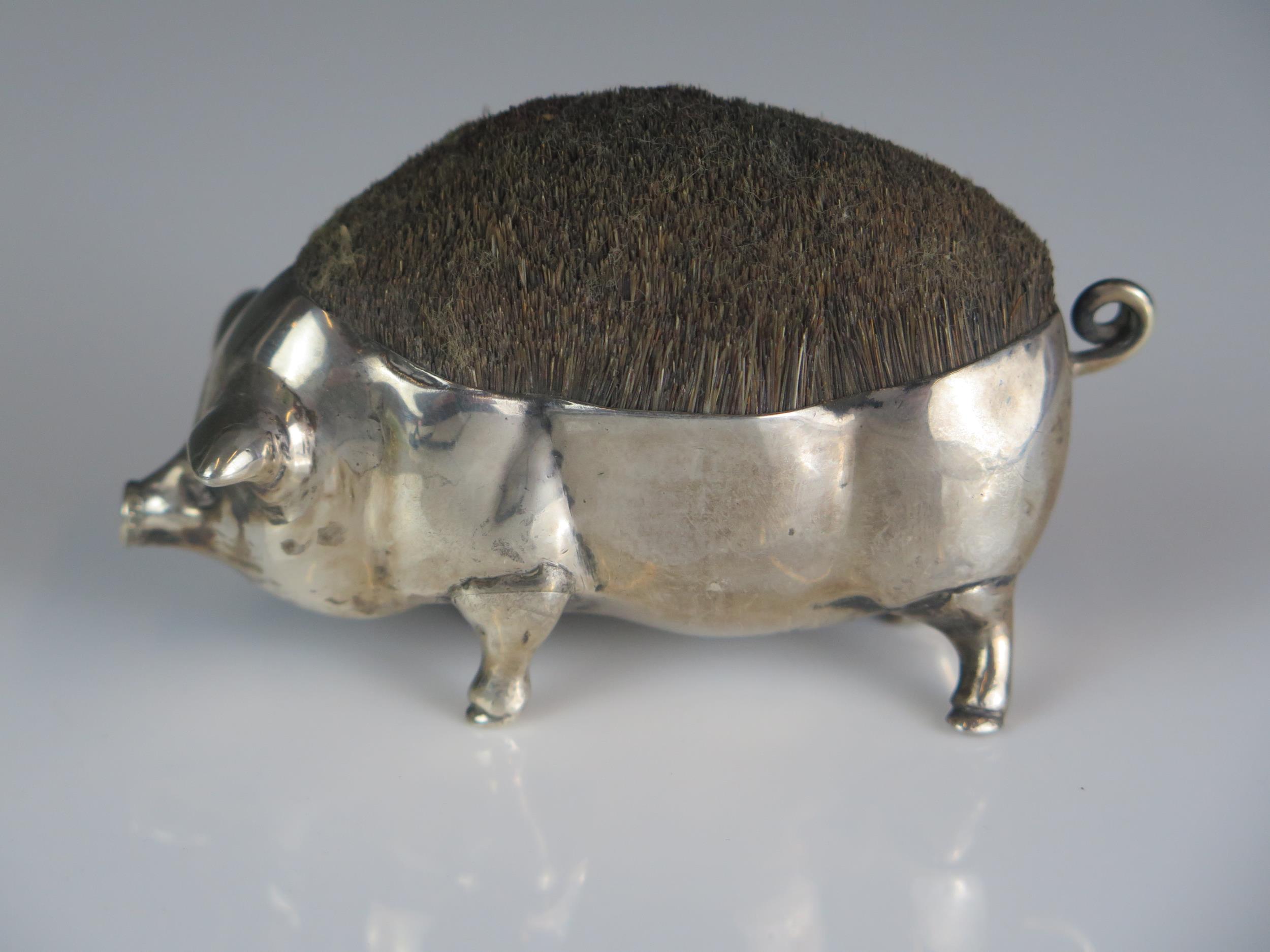 An Edward VII novelty nib cleaner, maker's mark worn, London, 1905, in the form of a pig, 9cm long.