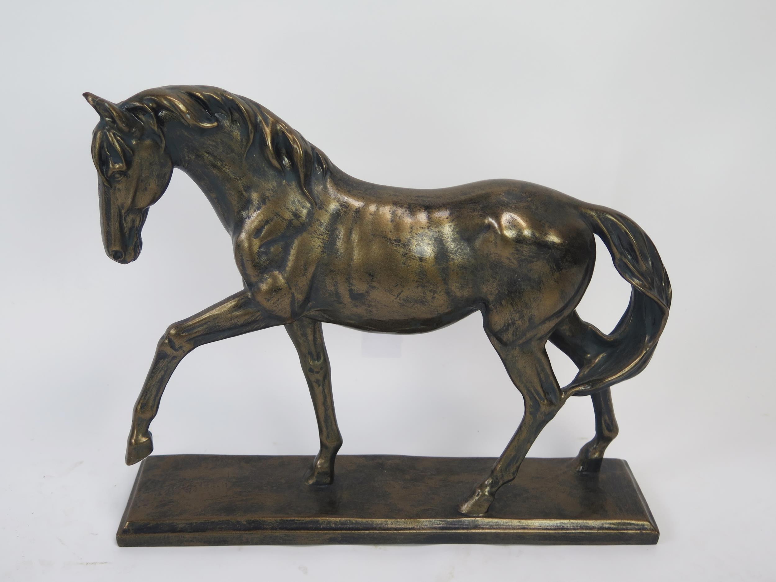 A bronzed resin model of a stallion, on a rectangular plinth base, 41cm long, 34cm high.