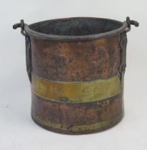 A 19th century brass and copper log bin of cylindrical form, with steel loop handle, 35cm high, 36cm