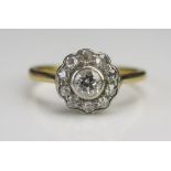 An 18ct Gold and Diamond Cluster Ring, c. 3.9mm old cut principal stoner in a rub over setting, 10mm