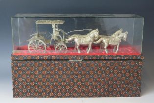 A far eastern white metal model of a horse drawn carriage, the covered wagon with driver figure