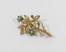 A 9 carat gold emerald and diamond set floral spray brooch, Birmingham 1989, set with 14 round