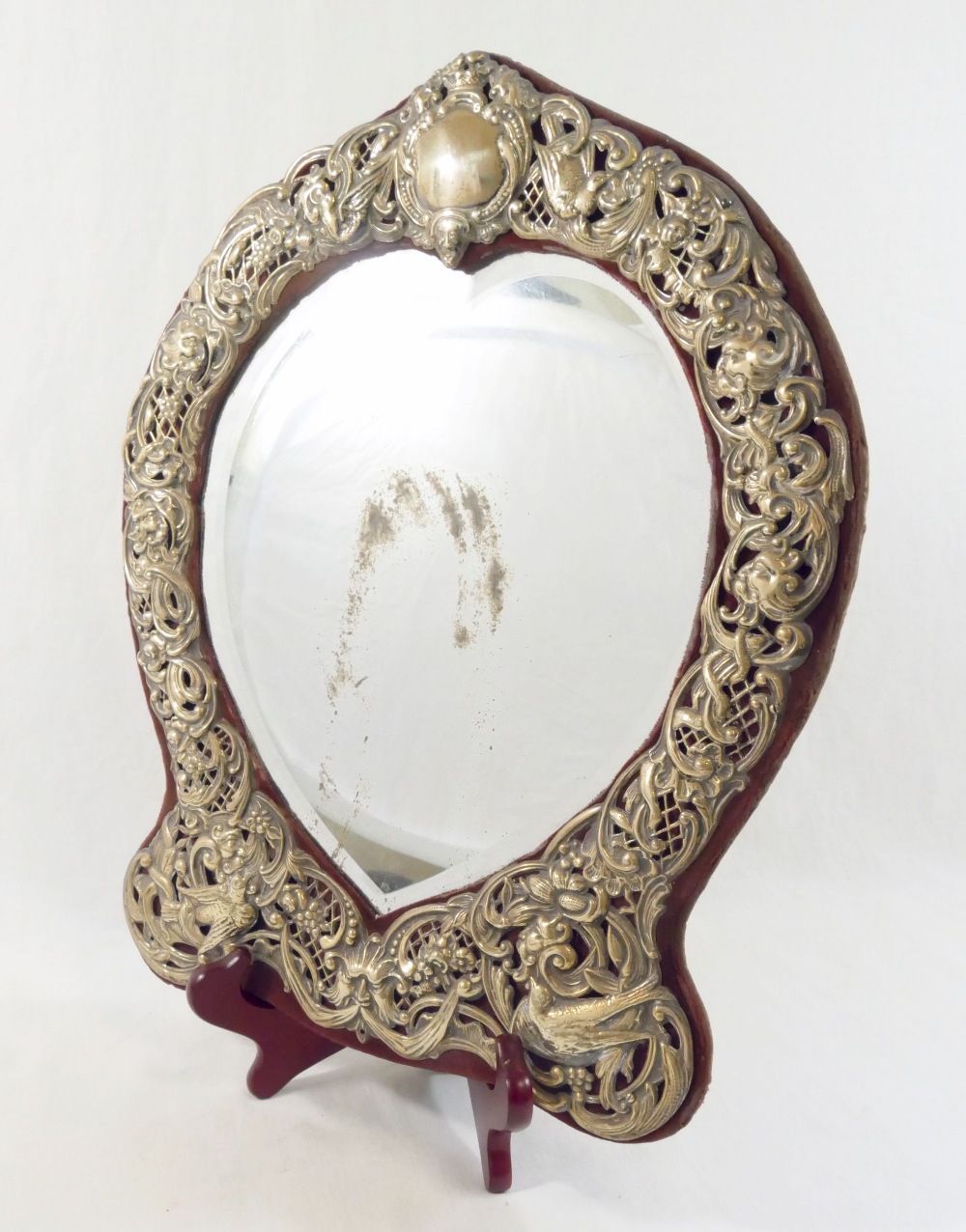 An early 20th century Continental heart-shaped bevelled edge dressing table mirror, within ornate