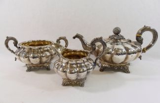 A William IV silver three-piece melon-shaped teaset, the teapot with lobed body raised on four