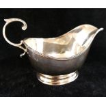 A silver gravy boat, Birmingham 1941, by Adies Bros., on oval pedestal foot, with double scroll