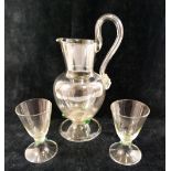 A Continental clear glass water set, comprised of a jug with large scroll handle, 25cm high, six