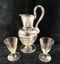 A Continental clear glass water set, comprised of a jug with large scroll handle, 25cm high, six