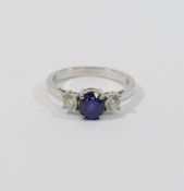 An 18 carat gold sapphire and diamond three stone ring, the oval mixed cut sapphire approximately