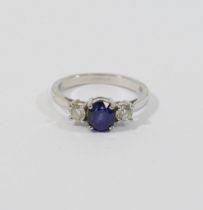 An 18 carat gold sapphire and diamond three stone ring, the oval mixed cut sapphire approximately