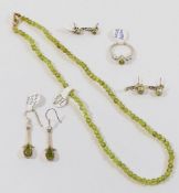 A small collection of peridot jewellery comprised of a beaded necklace, two pairs of stud