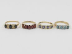 Two 9 carat gold gem-set half hoop rings, and two other gem-set rings including two sapphire and