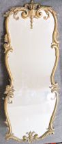 An ornate wall mirror, with gilt metal frame, cast with shells and scrolls, 98cm x 39cm CONDITION