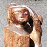 A large 20th century abstract wooden sculpture of a pregnant woman holding a child whilst standing