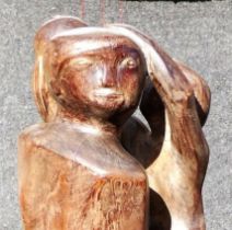 A large 20th century abstract wooden sculpture of a pregnant woman holding a child whilst standing