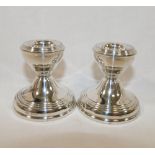 A pair of squat silver candlesticks, Birmingham 1964, filled, with circular bases, 5.8cm high