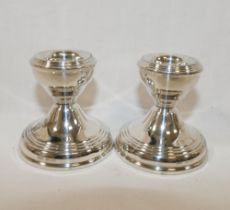 A pair of squat silver candlesticks, Birmingham 1964, filled, with circular bases, 5.8cm high