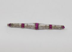 An Art Deco bi-colour ruby and diamond set bar brooch, unmarked, 6.8cm long, 5.4g gross CONDITION