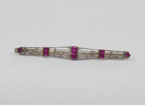 An Art Deco bi-colour ruby and diamond set bar brooch, unmarked, 6.8cm long, 5.4g gross CONDITION